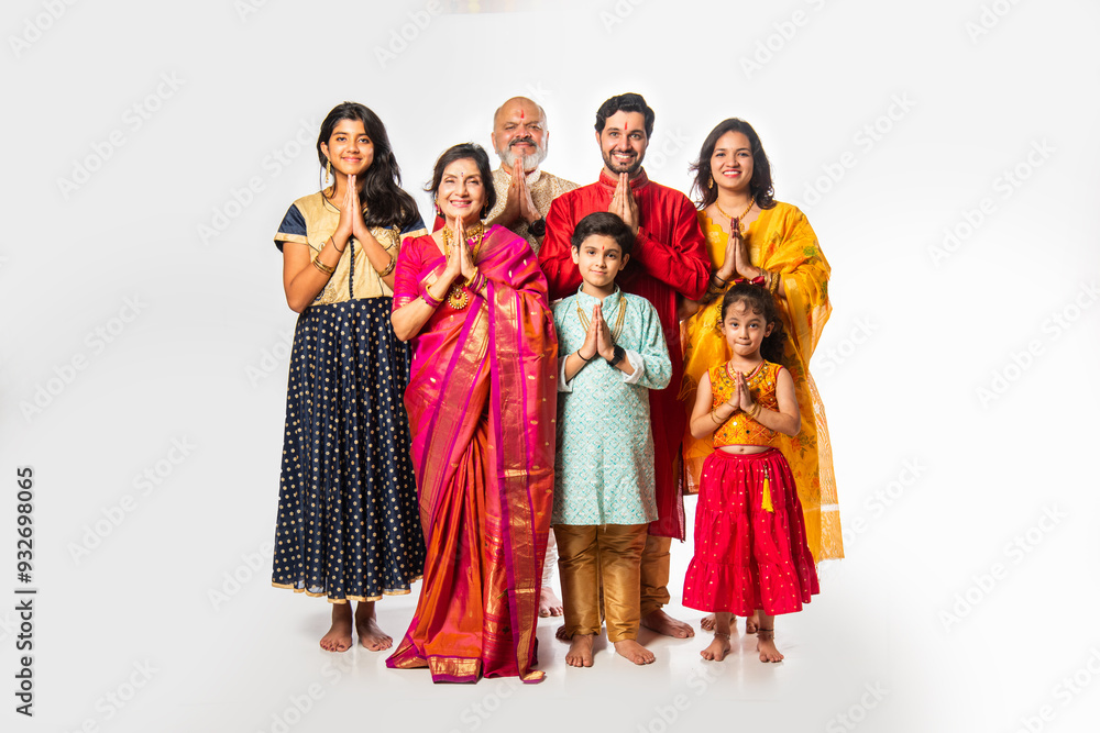 Indian family in festive mood, welcoming guests with Namaste while looking at the camera Indian family in festive mood, welcoming guests with Namaste while looking at the camera