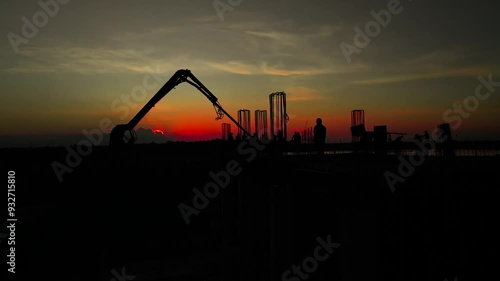 silhouettes of workers in a building construction in the afternoon