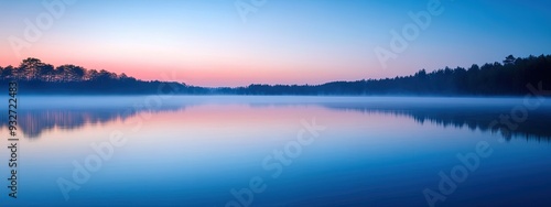 Lake at dawn, mist rising from water, soft pink and blue sky, gentle morning light photo