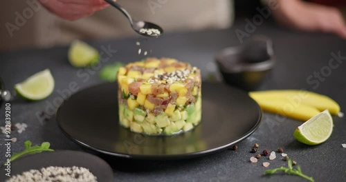 Traditional tuna and mango tartare on black ceramic plate