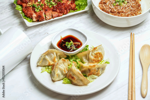 Pan fried dumplings with dipping sauce, pork chop, minced pork rice served in plate isolated on marble background side view of taiwan food