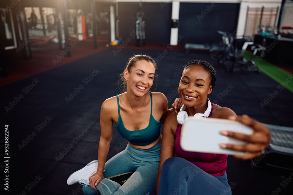 Young happy sportswomen taking selfie with cell phone in gym. Young happy sportswomen taking selfie with cell phone in gym.