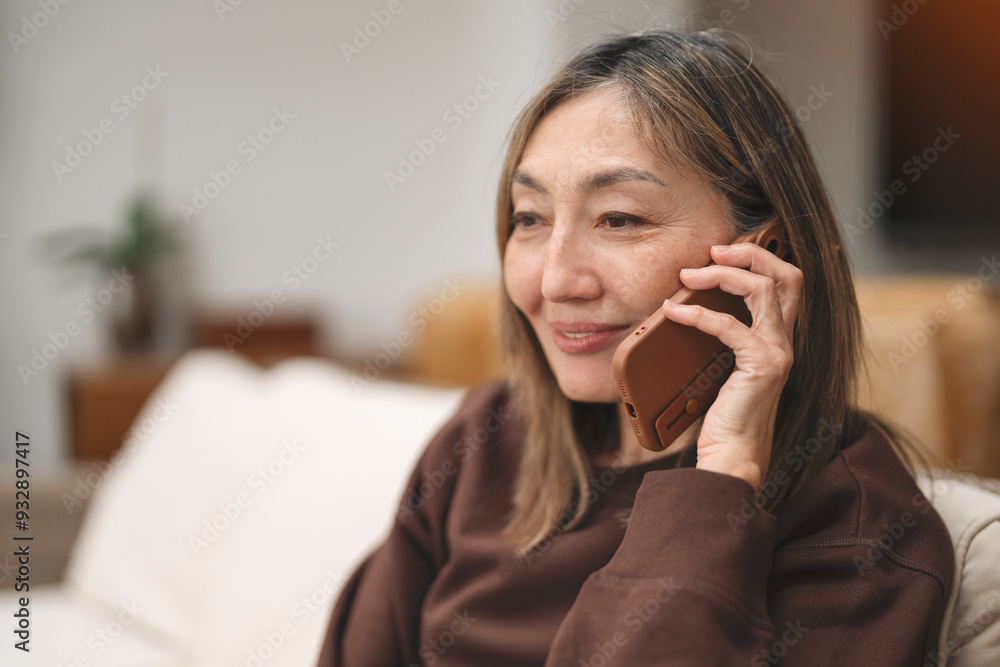 Woman Talking on Smartphone While Sitting Comfortably Indoors in Cozy Lighting Woman Talking on Smartphone While Sitting Comfortably Indoors in Cozy Lighting