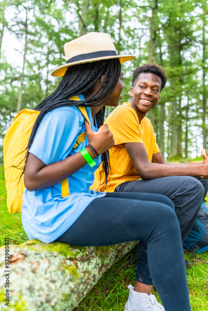 African friends sitting enjoying nature during hiking in the forest African friends sitting enjoying nature during hiking in the forest