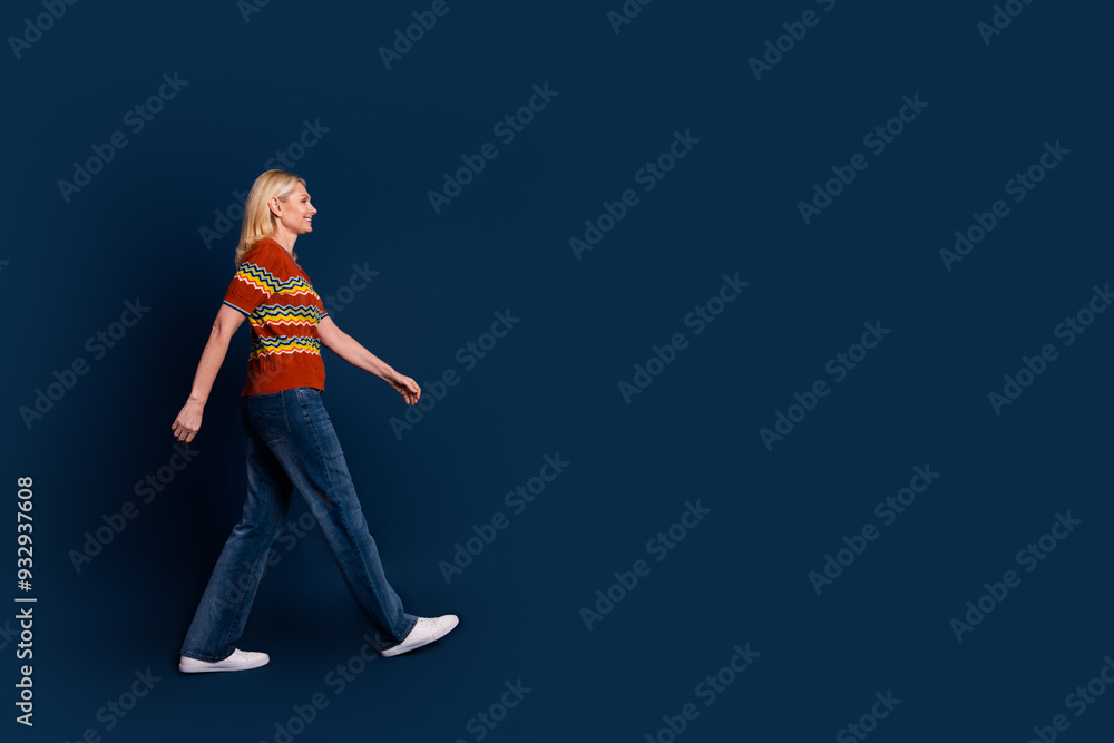 Photo of charming adorable senior woman wear striped trendy clothes walk empty space isolated on dark blue color background Photo of charming adorable senior woman wear striped trendy clothes walk empty space isolated on dark blue color background