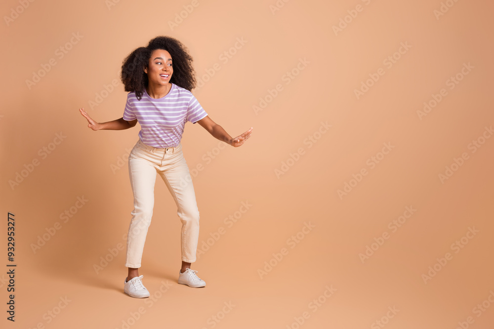 Full length portrait of pretty young woman dancing empty space wear t-shirt isolated on beige color background Full length portrait of pretty young woman dancing empty space wear t-shirt isolated on beige color background