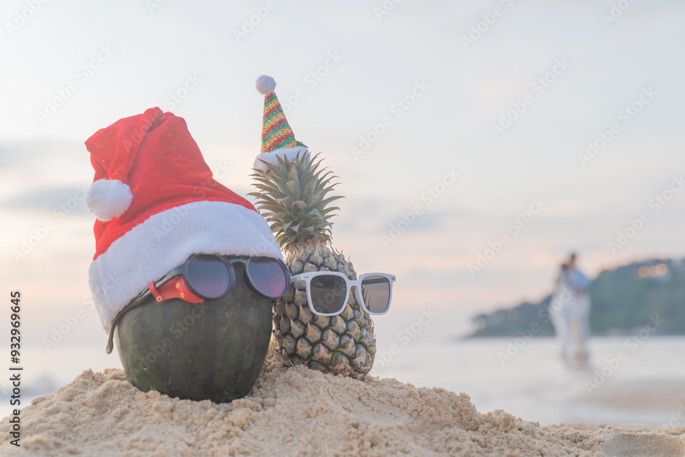 Φωτογραφία Santa Claus pineapple and watermelon couple wearing stylish sunglasses on the sand contrasting with the sea