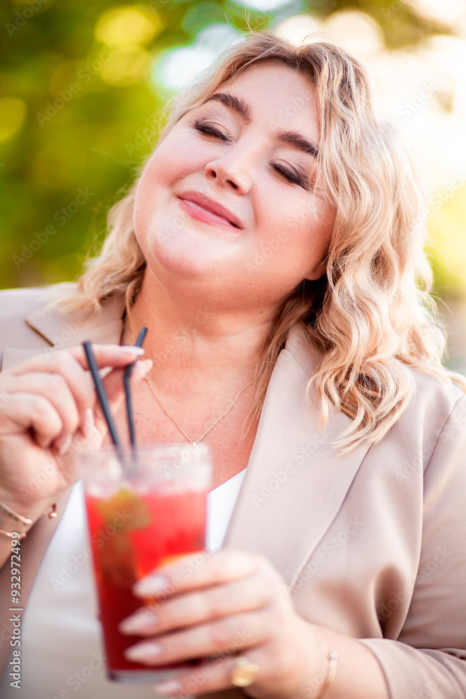 A beautiful large woman is relaxing in a cafe with a drink A beautiful large woman is relaxing in a cafe with a drink