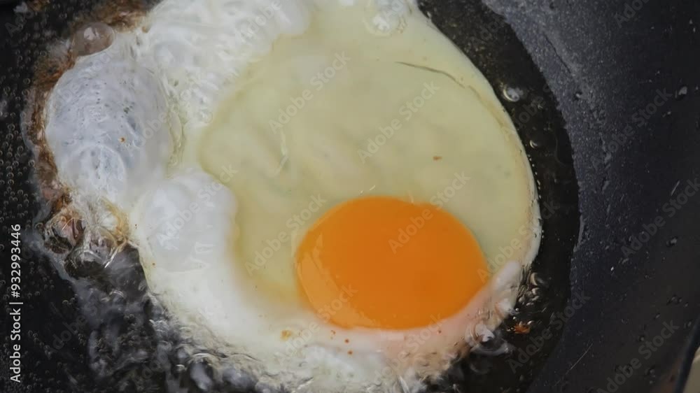 Delicious Fried Egg Sizzling in the Pan. Sunny Side Up.