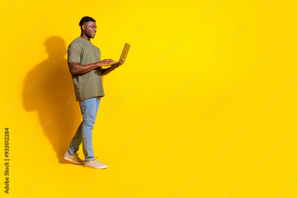Photo of cheerful positive man wear trendy khaki clothes walk empty space isolated on yellow color background Photo of cheerful positive man wear trendy khaki clothes walk empty space isolated on yellow color background