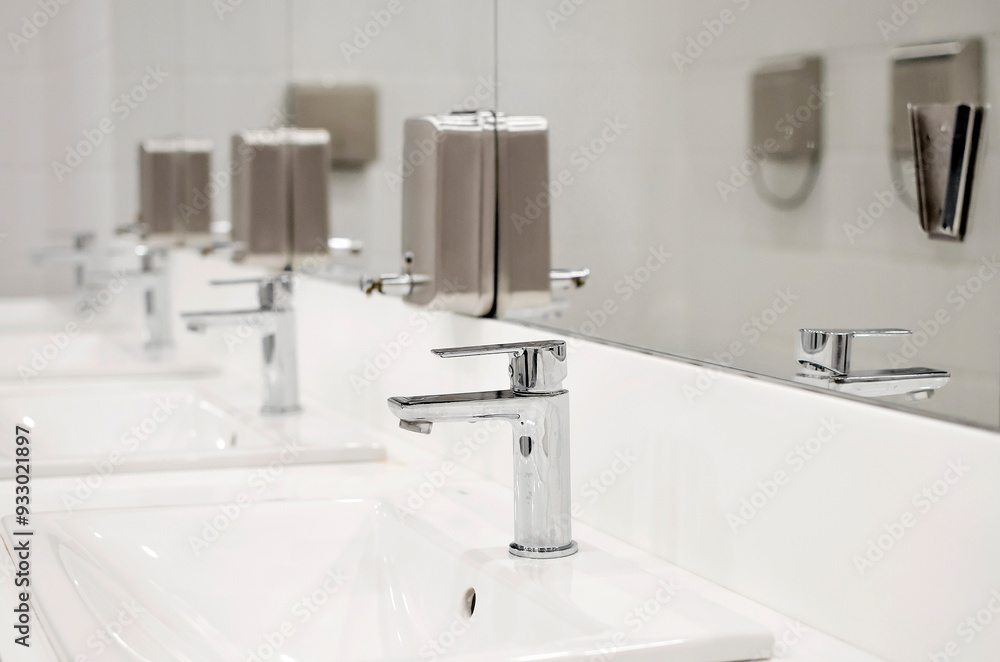 interior shot of a modern bathroom in the foreground the washbasin with a steel tap interior shot of a modern bathroom in the foreground the washbasin with a steel tap