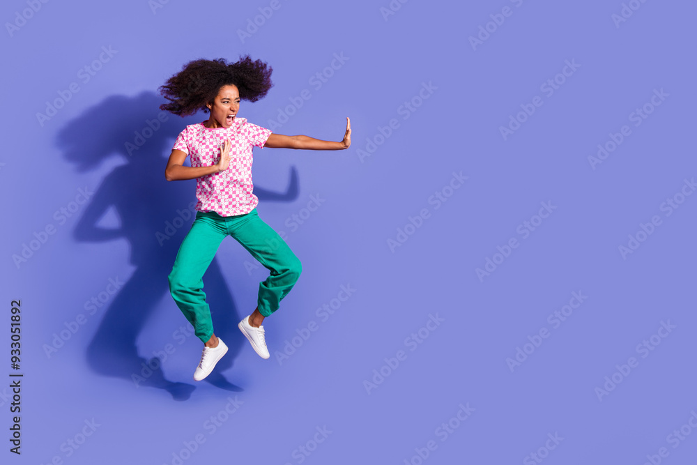 Full body photo of attractive young woman kick fight empty space dressed stylish pink clothes isolated on violet color background Full body photo of attractive young woman kick fight empty space dressed stylish pink clothes isolated on violet color background