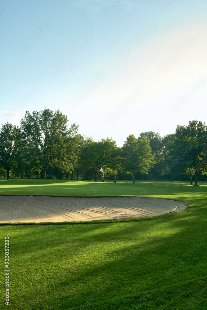 Tranquil Golf Course with Sand Bunker and Flag surrounded by lush trees under a clear blue sky. Perfect for concepts of relaxation, nature, and outdoor sports. Tranquil Golf Course with Sand Bunker and Flag surrounded by lush trees under a clear blue sky. Perfect for concepts of relaxation, nature, and outdoor sports.