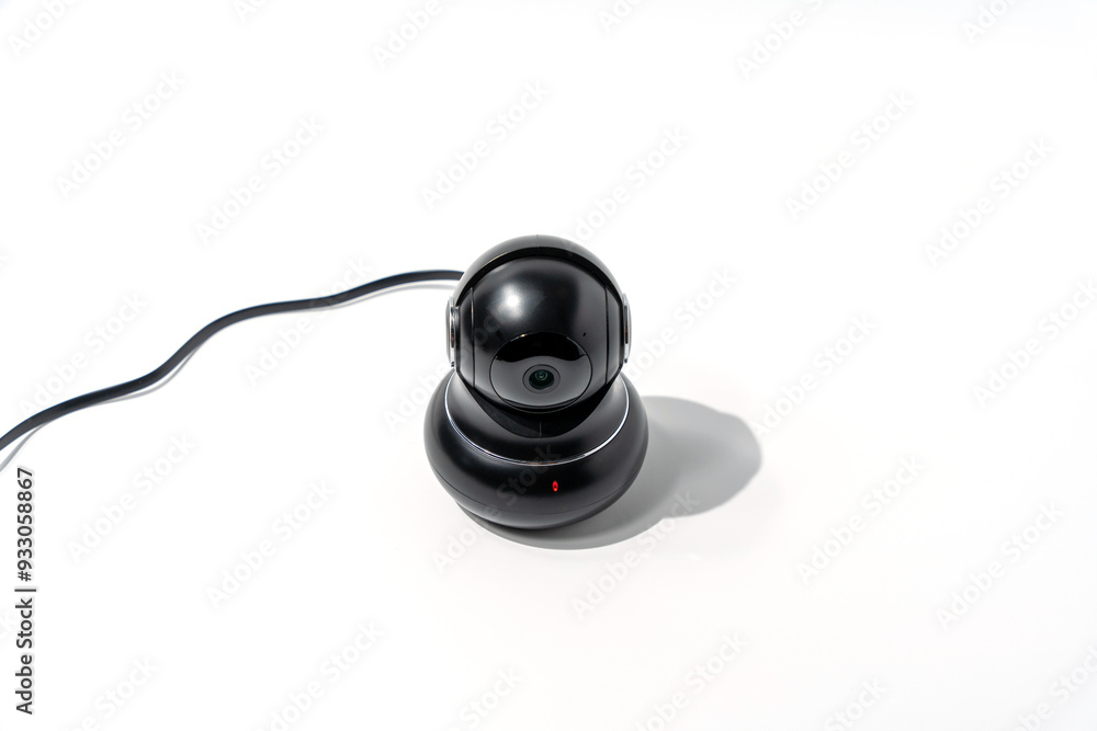 A black camera sits on a white surface. CCTV camera isolated on white background. A black camera sits on a white surface. CCTV camera isolated on white background.