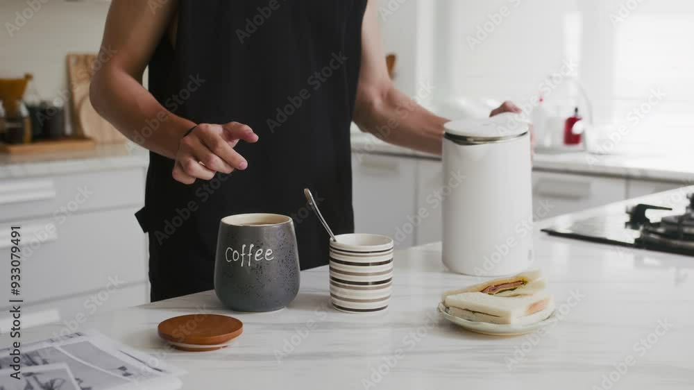 Cropped shot of anonymous man having coffee and sandwich for breakfast at home Cropped shot of anonymous man having coffee and sandwich for breakfast at home