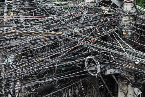 Hundreds of suspended electric cables crossing each other high above the city street photo