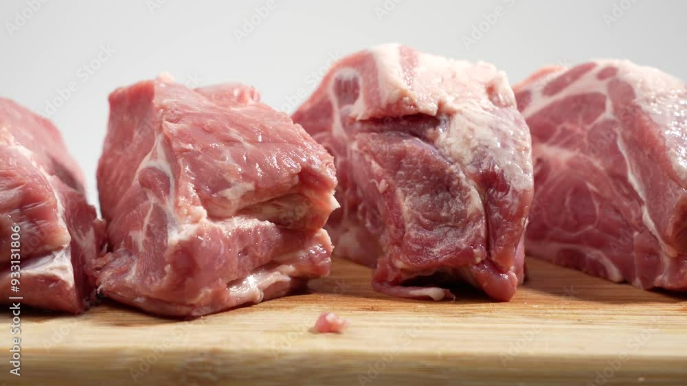 Pork meat on a cutting board rotates on a white background. Raw pork meat on white. Pork meat on a cutting board rotates on a white background. Raw pork meat on white.