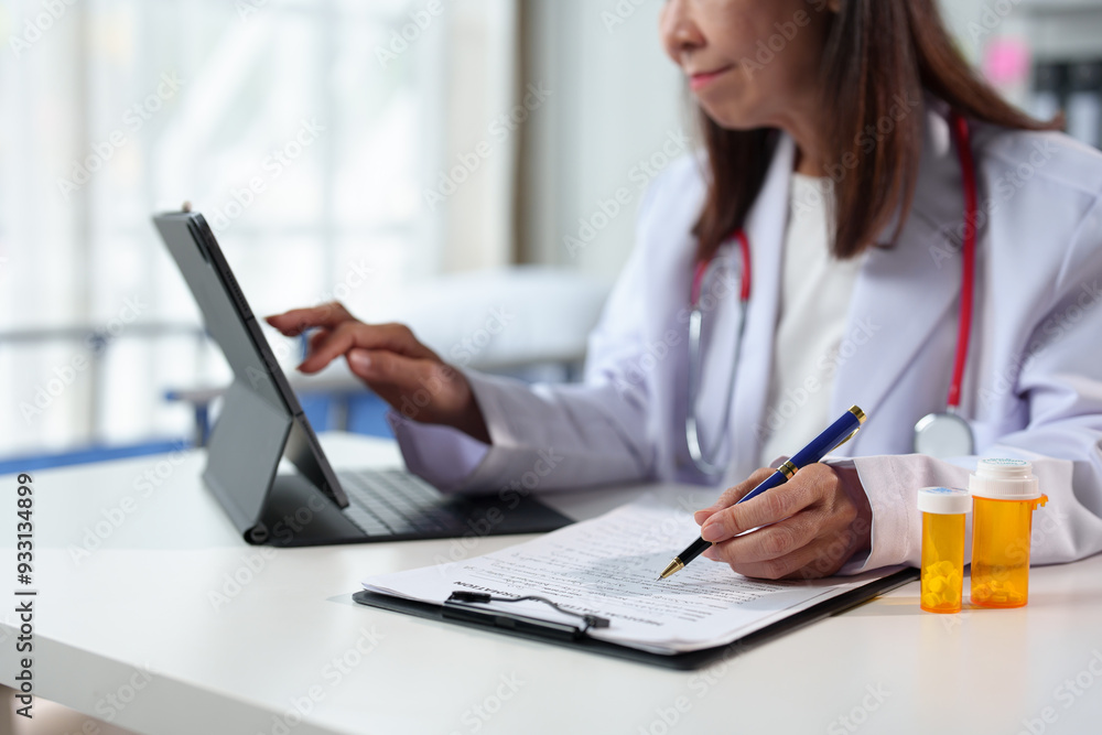 Young female doctor sitting at the desk preparing to receive patients in the medical clinic. Medicine. Data recording. Medical personnel at a clinic or hospital. Young female doctor sitting at the desk preparing to receive patients in the medical clinic. Medicine. Data recording. Medical personnel at a clinic or hospital.