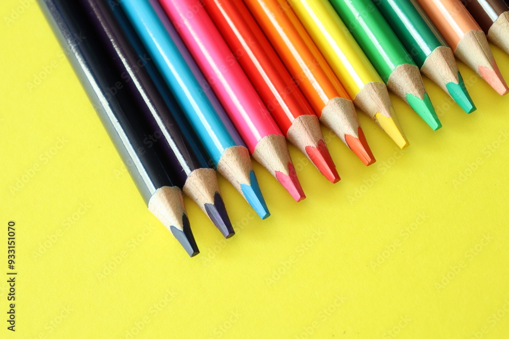Fototapeta premium a group of multi-colored colorful large pencils on a yellow background