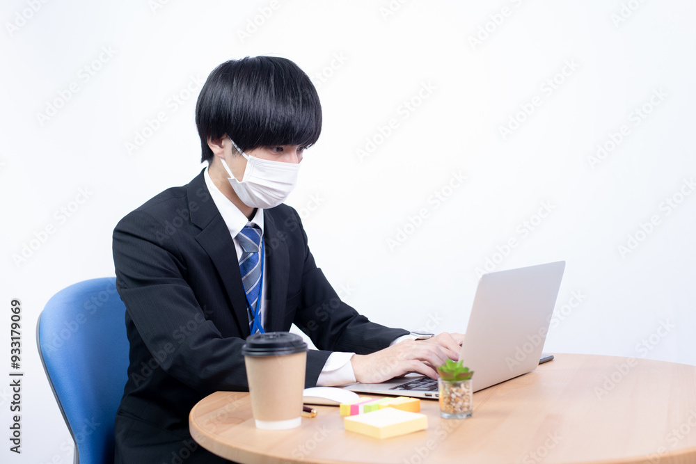 マスクをして作業をする若いビジネスマン マスクをして作業をする若いビジネスマン