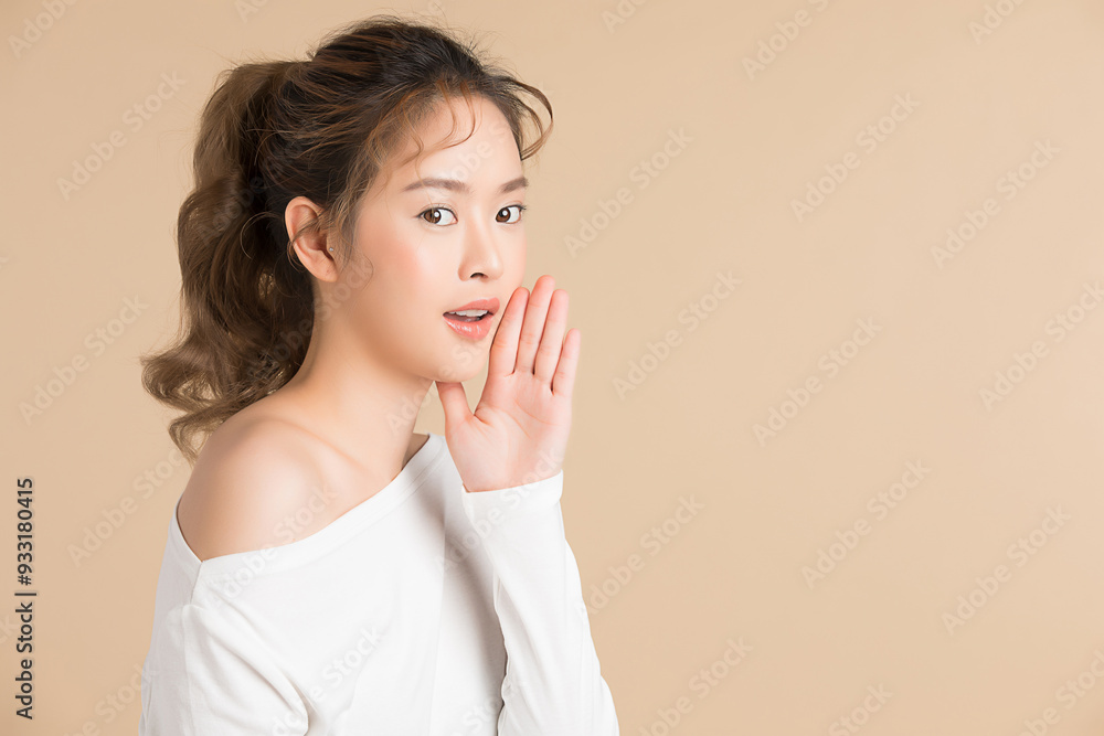 手を口に当てるポーズをしている若い女性モデル 手を口に当てるポーズをしている若い女性モデル