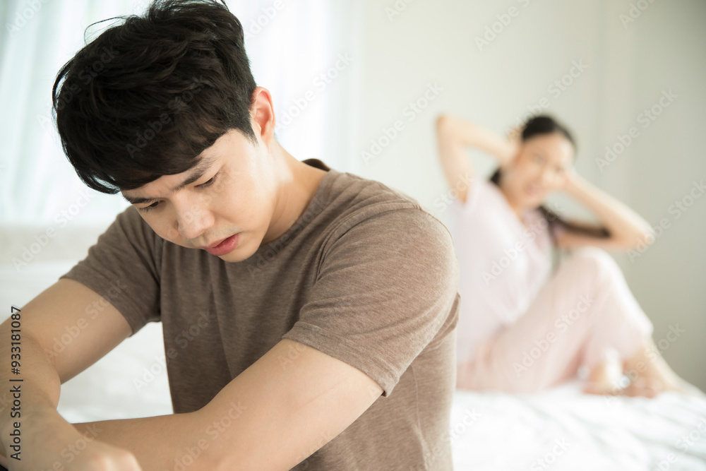 夫婦喧嘩中で手で耳を塞いでしまう女性と落ち込む男性 夫婦喧嘩中で手で耳を塞いでしまう女性と落ち込む男性