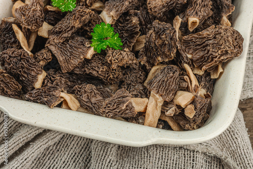 Raw black morel mushrooms with fresh parsley. Vegan ingredient for cooking healthy food photo