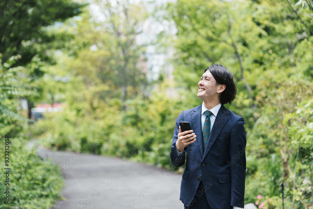 通勤中にスマートフォンを使用するビジネスマン・IoTイメージ