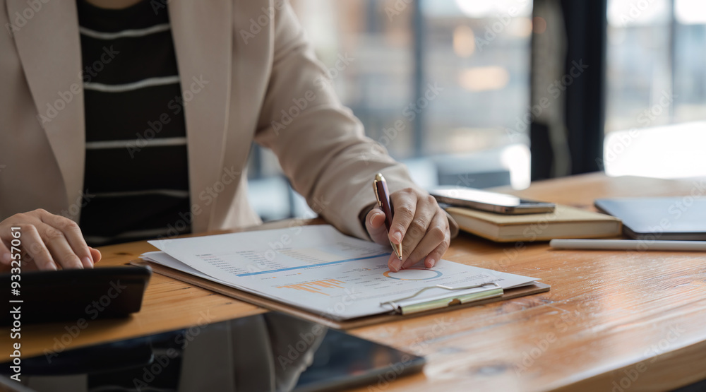 Businessman Analyzing Company Stock Charts and Taking Notes in a Modern Office Setting for Financial Planning Businessman Analyzing Company Stock Charts and Taking Notes in a Modern Office Setting for Financial Planning