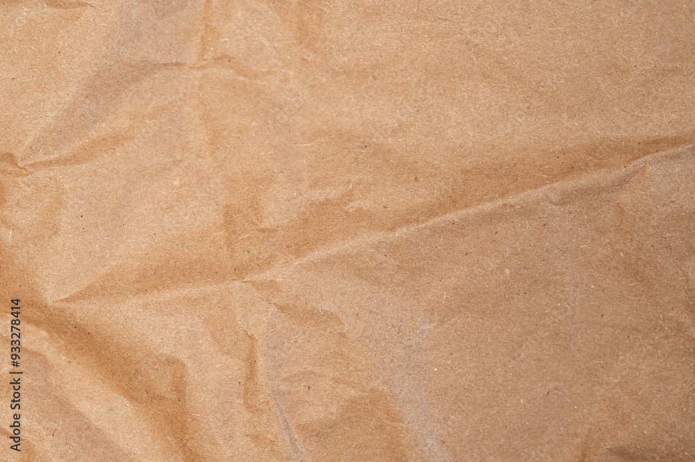 Fototapeta premium Brown craft baking paper sheet top view background, parchment for baking culinary, piece of wrinkled or crumpled paper texture