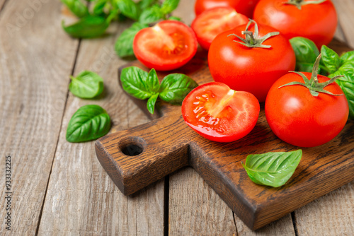 Fresh cherry tomatoes and fresh green basil on a textured background. Tomato sauce. Vegan. Ingredients for salad. Organic food. Place for text. Copy space.