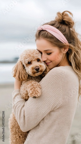 Girl embraces her fluffy dog on the beach at sunset