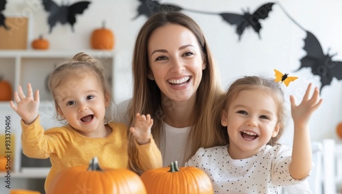 Smiling mother and children enjoying pumpkin carving activity at home in autumn