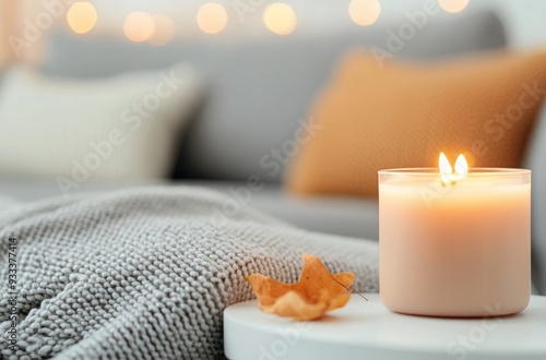 Cozy living room setting with lit candles and soft blankets during festive se...