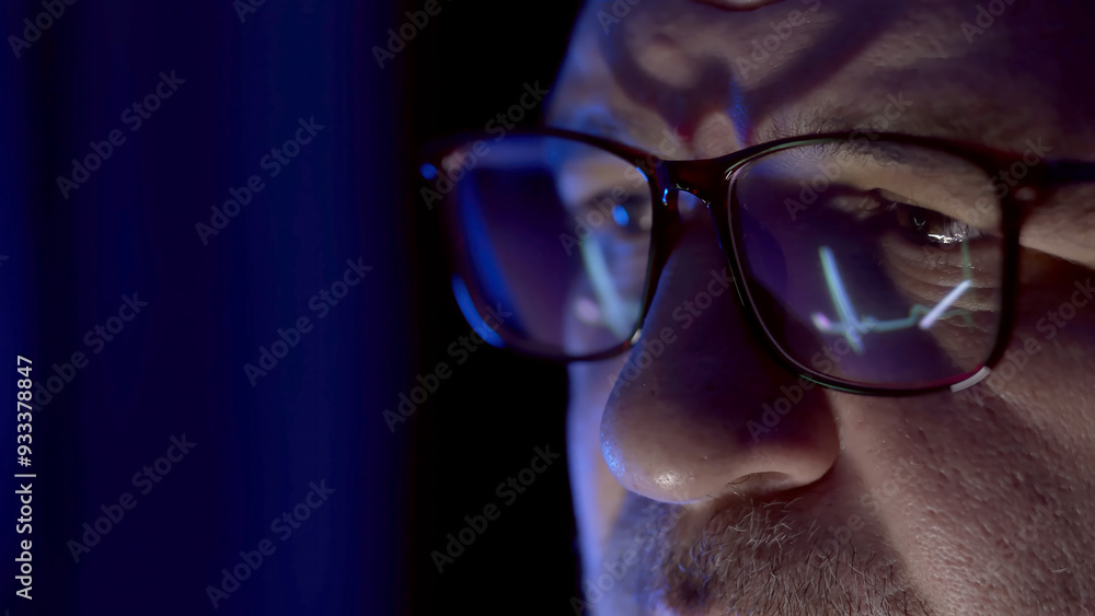Close-up of a developer wearing glasses, coding on a computer. Code and analytics reflections in the glasses emphasize focus on cybersecurity and software development. Close-up of a developer wearing glasses, coding on a computer. Code and analytics reflections in the glasses emphasize focus on cybersecurity and software development.