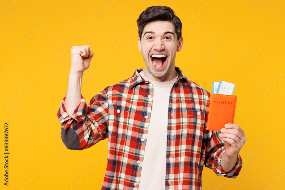 Traveler winner happy man wear red shirt casual clothes hold passport ticket isolated on plain yellow background. Tourist travel abroad in free spare time rest getaway Air flight trip journey concept Traveler winner happy man wear red shirt casual clothes hold passport ticket isolated on plain yellow background. Tourist travel abroad in free spare time rest getaway Air flight trip journey concept