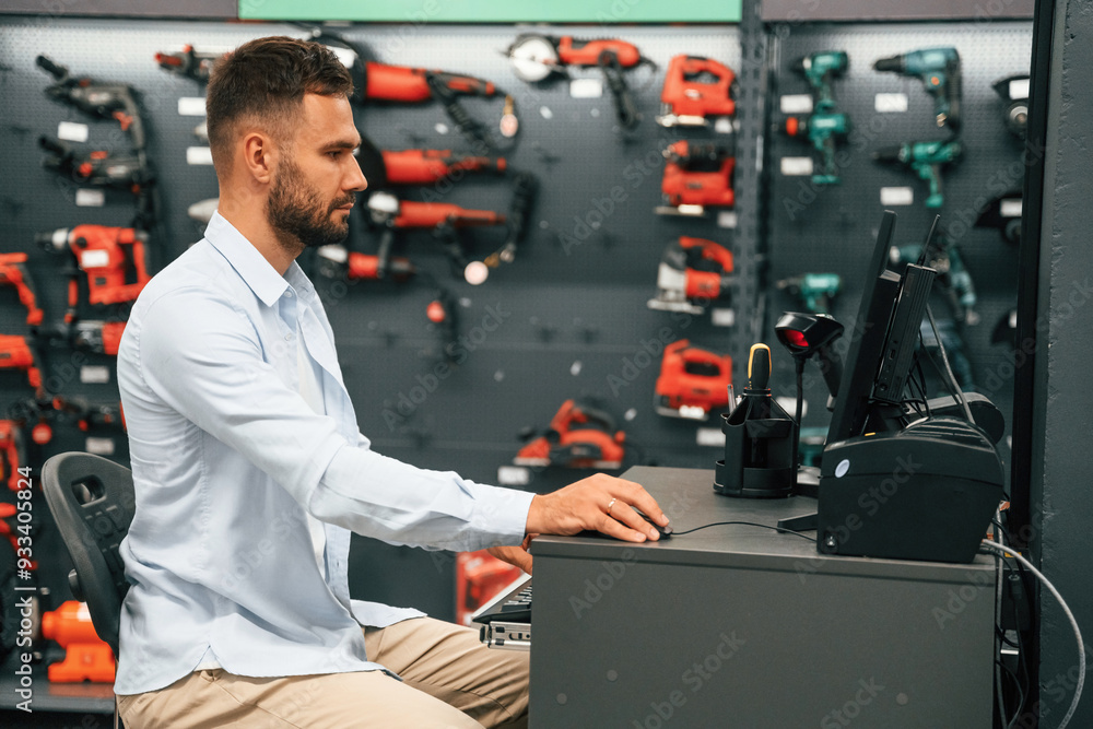 Cashier is at work. Man is in the hardware shop Cashier is at work. Man is in the hardware shop