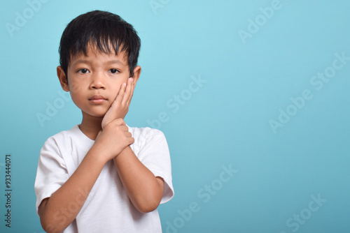 Little Asian boy suffering from toothache. emotional Asian boy who is suffering. A sad child with a toothache. Dental problem. A place for your text.