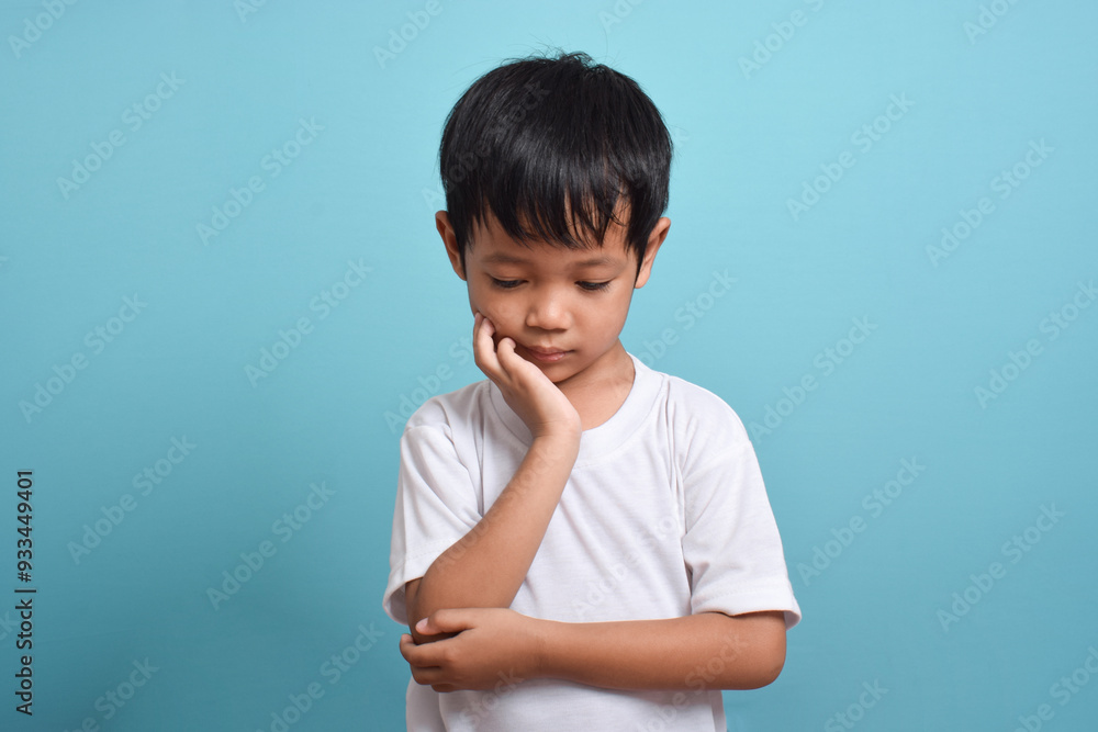Little Asian boy suffering from toothache. toothache emotions large inflated cheek. A sad child with a toothache. Dental problem. Little Asian boy suffering from toothache. toothache emotions large inflated cheek. A sad child with a toothache. Dental problem.