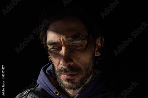 mirada baja de hombre con poca luz sobre su rostro