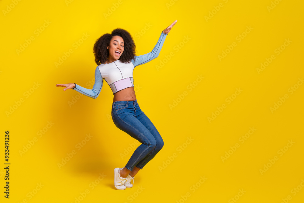Full body photo of attractive young woman dancing have fun dressed stylish blue clothes isolated on yellow color background Full body photo of attractive young woman dancing have fun dressed stylish blue clothes isolated on yellow color background