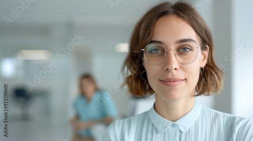 Confident Businesswoman in Modern Office Setting with Team Member in Background, Professional and Motivated