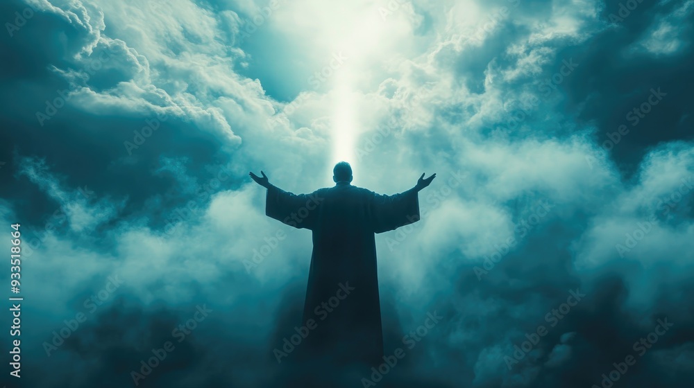 Silhouette of a man in a religious robe praying with arms lifted, as holy light pierces through clouds and fog, symbolizing faith and devotion. Silhouette of a man in a religious robe praying with arms lifted, as holy light pierces through clouds and fog, symbolizing faith and devotion.