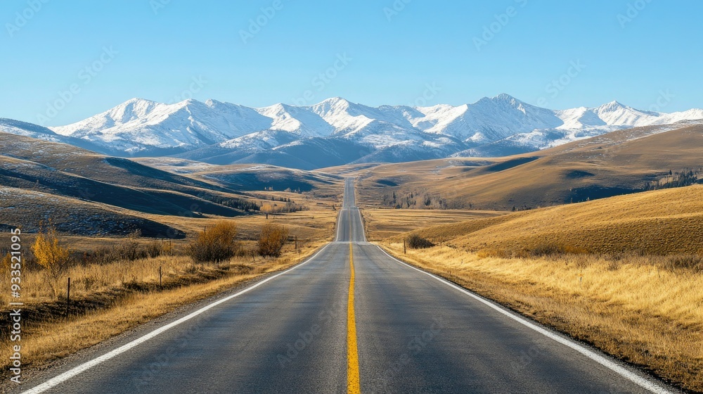 A road stretching through rolling hills with snow-capped mountains in the distance, under a clear blue sky. A road stretching through rolling hills with snow-capped mountains in the distance, under a clear blue sky.