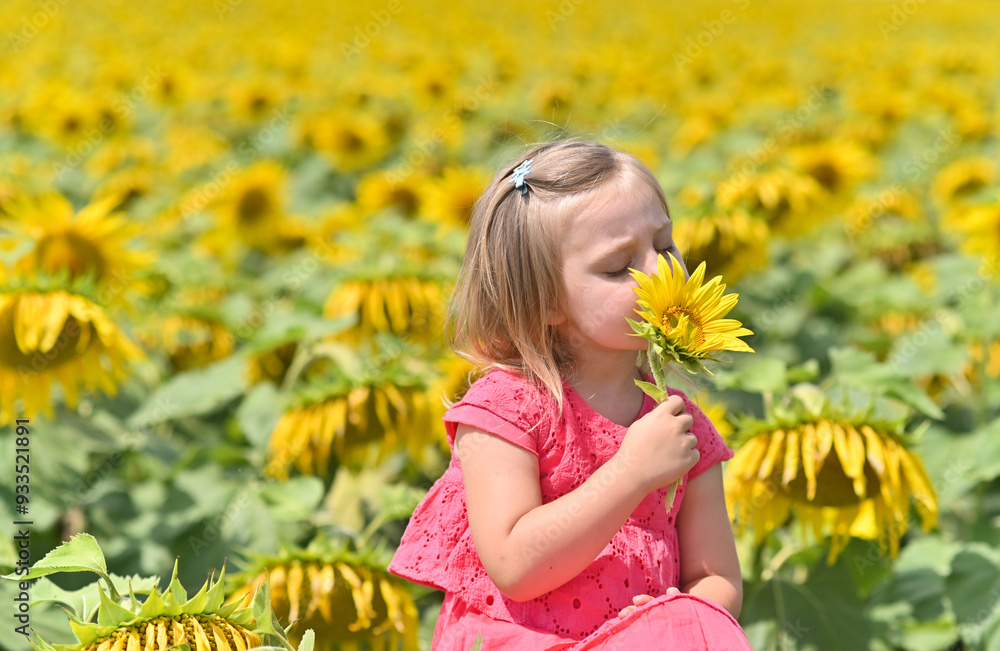 Naklejka premium portrait of a 3-year-old girl with a sunflower flower