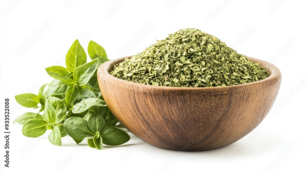 A rustic wooden bowl filled with dried oregano flakes, complemented by fresh oregano leaves, all neatly arranged and isolated on a white background. A rustic wooden bowl filled with dried oregano flakes, complemented by fresh oregano leaves, all neatly arranged and isolated on a white background.