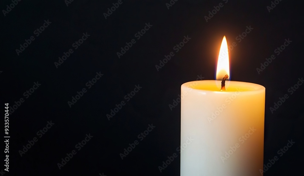 A close-up view of a burning white candle against a black background A close-up view of a burning white candle against a black background