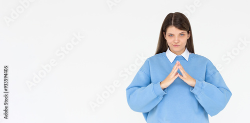 I have great evil plan. Confident and tricky woman in blue sweatshirt, holding fingers together and smirking at camera, having some bad intention in mind, planning to commit crime