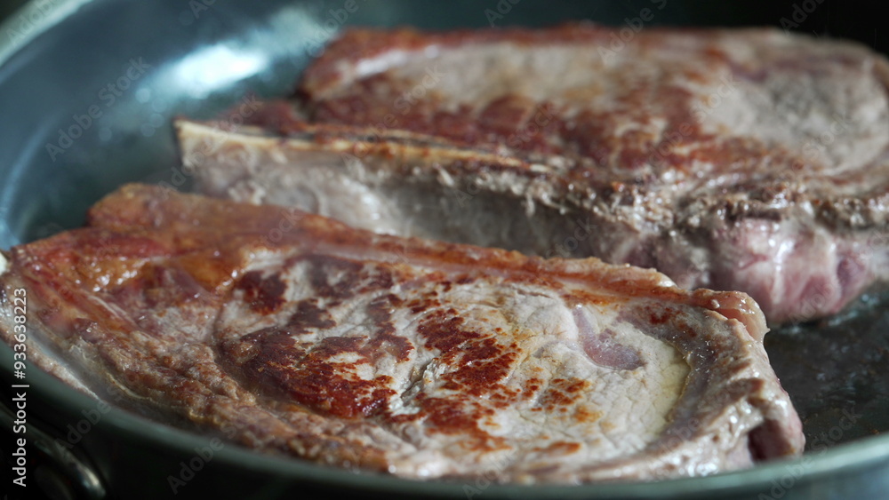 Partially cooked steaks in a pan, starting to brown, close-up view, home cooking, delicious meal in progress, fresh beef, culinary preparation, sizzling sound, detailed kitchen scene Partially cooked steaks in a pan, starting to brown, close-up view, home cooking, delicious meal in progress, fresh beef, culinary preparation, sizzling sound, detailed kitchen scene