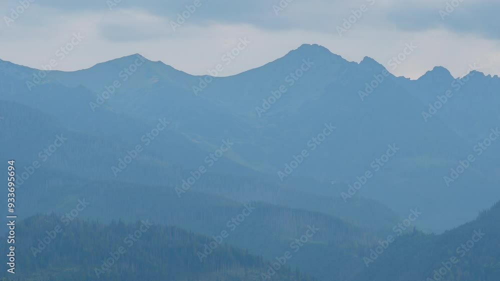Time-lapse mountains covered with rolling rainy clouds. Mountain peaks in Tatra mountains, Poland. Cloudy summer day. Epic rocky highlands and hills covered with green pine trees forest Time-lapse mountains covered with rolling rainy clouds. Mountain peaks in Tatra mountains, Poland. Cloudy summer day. Epic rocky highlands and hills covered with green pine trees forest